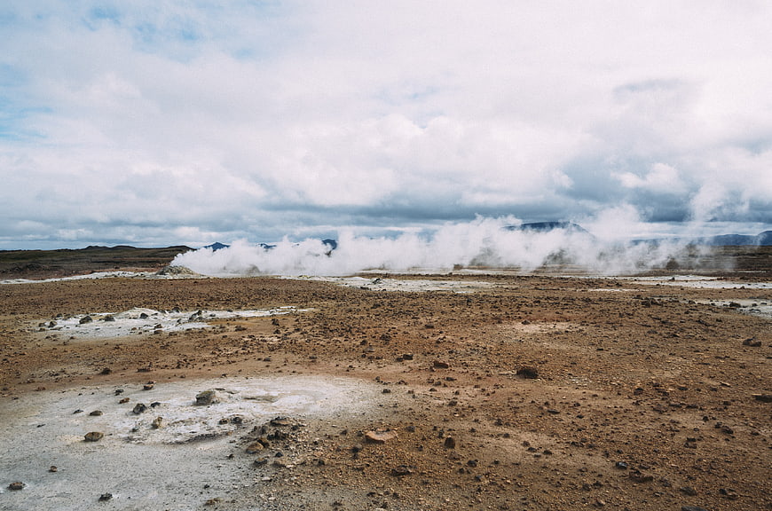Geothermal steam rising from barren volcanic landscape