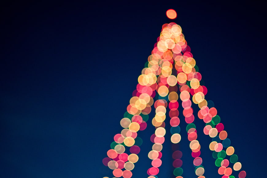 Abstract Bokeh Christmas Tree Lights on Dark Blue Background