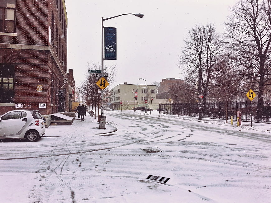 Snowy Brooklyn Street Scene with Brick Buildings and Parked Car