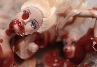 Close-up of creepy blonde doll covered in fake blood