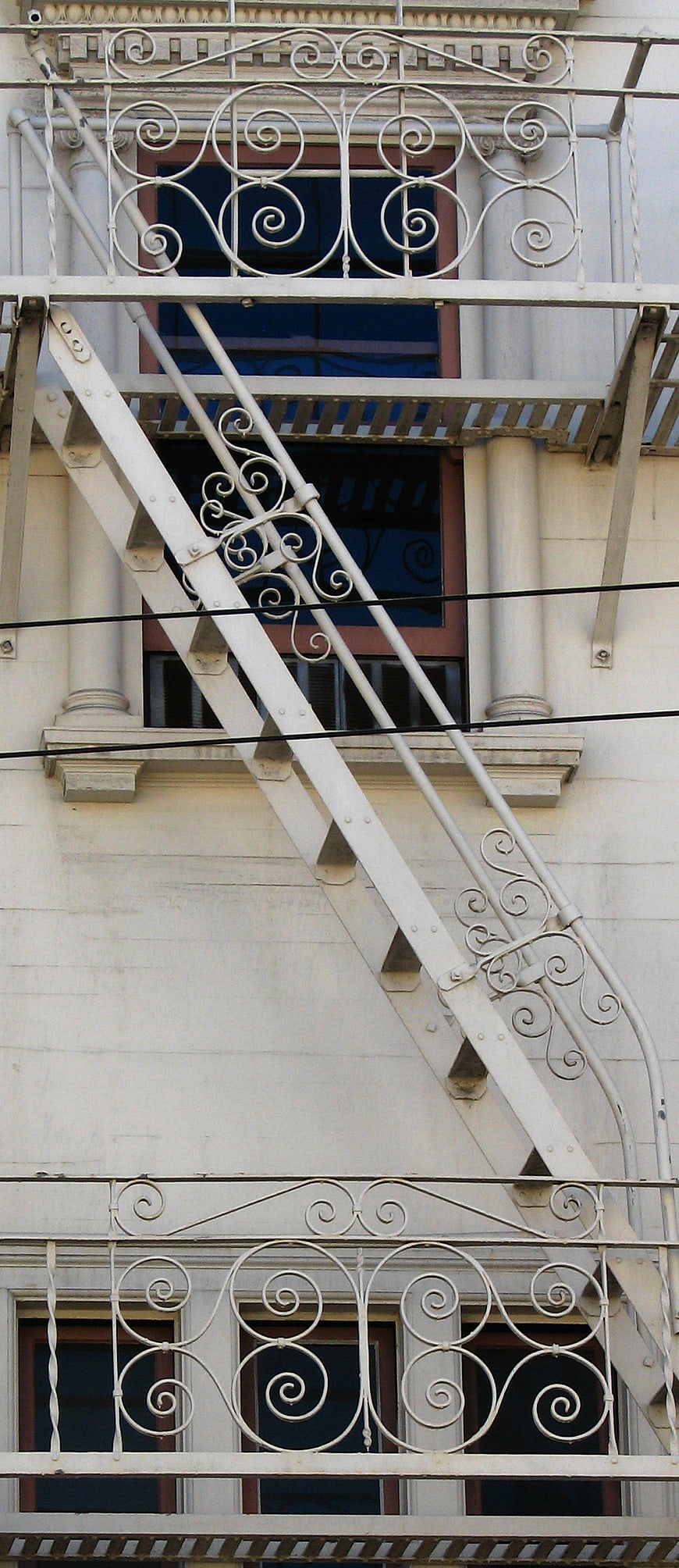 White Fire Escape Staircase with Ornate Metal Railings