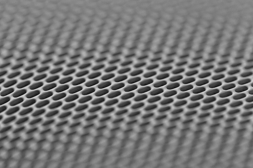 Close-up of gray perforated metal mesh texture background