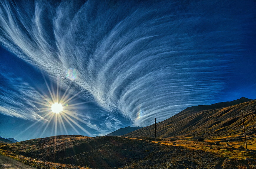 Dramatic Cirrus Clouds Over Mountain Landscape at Sunset