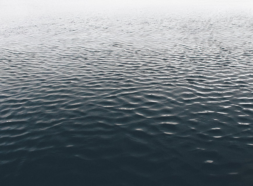 Calm Ocean Water Surface with Gentle Ripples and Misty Horizon