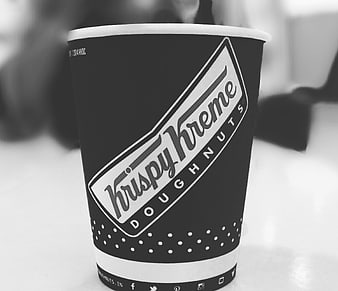 Black and White Krispy Kreme Coffee Cup on Table