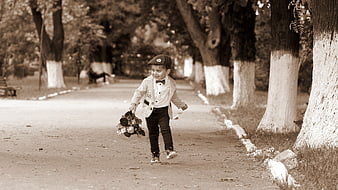 Toddler boy running in park with bouquet of flowers