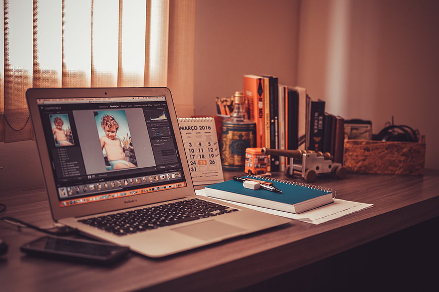 Home Office Workspace With Laptop, Notebook, And Books