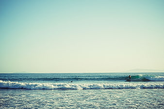 Surfer riding a wave on a sunny ocean day
