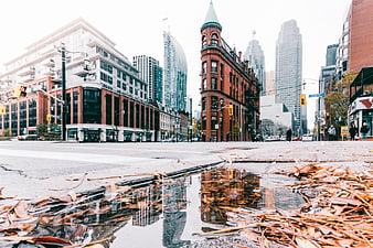 Low angle urban street with puddle reflection and historic architecture