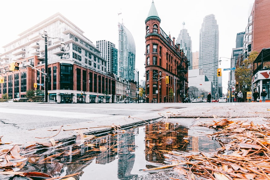 Low angle urban street with puddle reflection and historic architecture