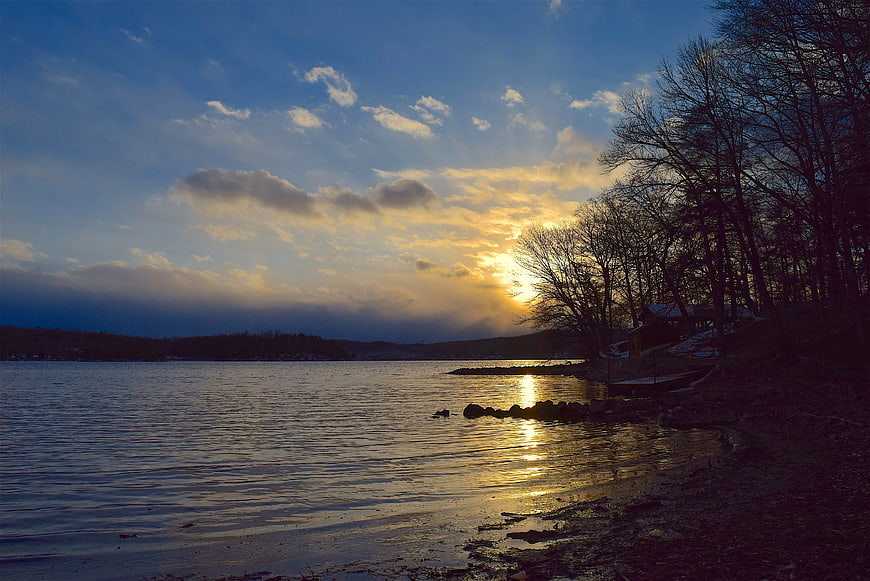 Serene Lake Sunset with Golden Reflections and Silhouetted Trees