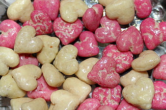 Close-up of pink and beige heart-shaped candies on foil
