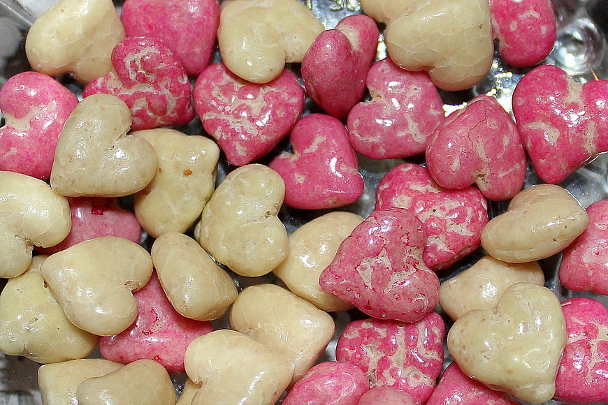 Close-up of pink and beige heart-shaped candies on foil