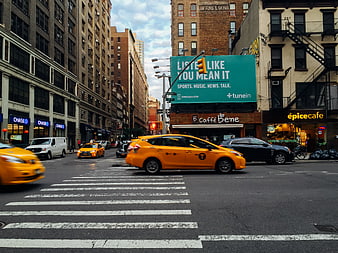 Yellow Taxi Driving Through New York City Street Intersection