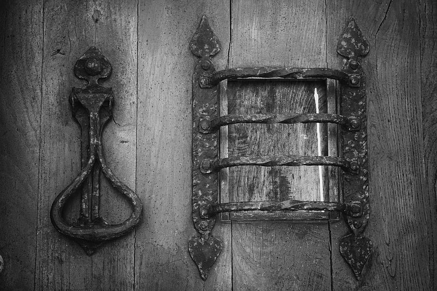 Vintage wrought iron door handle and latch on weathered wood