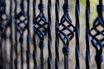 Close-up of black wrought iron fence with twisted metal design