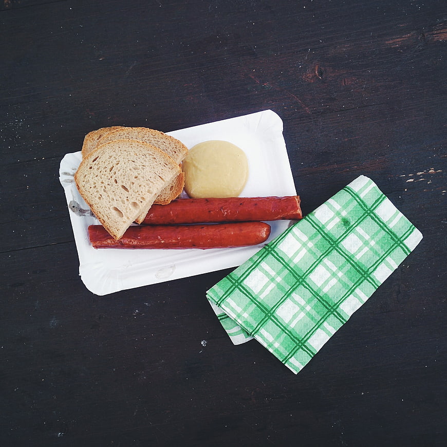 Top view of traditional Czech smoked sausage with bread and mustard