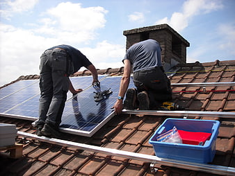 Workers Installing Solar Panels on Residential Roof