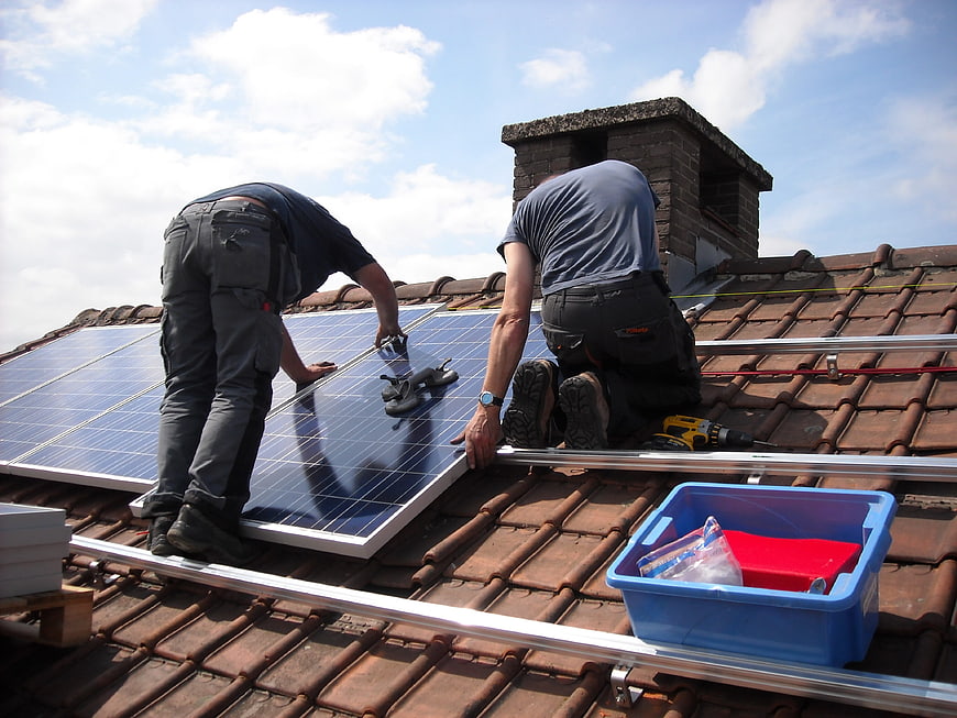 Workers Installing Solar Panels on Residential Roof
