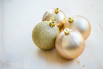 Gold Christmas Baubles on Light Wooden Table