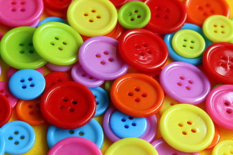Colorful Plastic Buttons Scattered On Yellow Surface