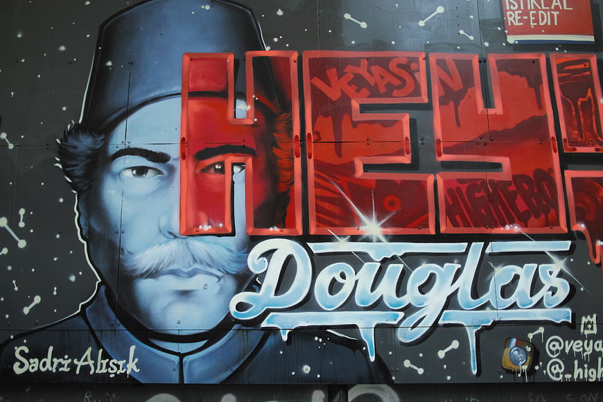 Urban street art mural with red and blue graffiti lettering