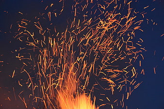 Dynamic Orange Sparks Flying Against Dark Blue Background