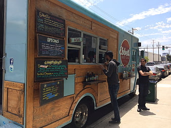 Food Truck With Wooden Paneling And Chalkboard Menu On City Street