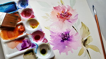 Watercolor floral painting with palette and brushes on paper