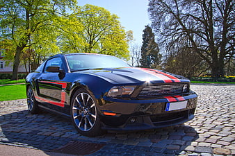Black Ford Mustang GT with Red Stripes on Cobblestone