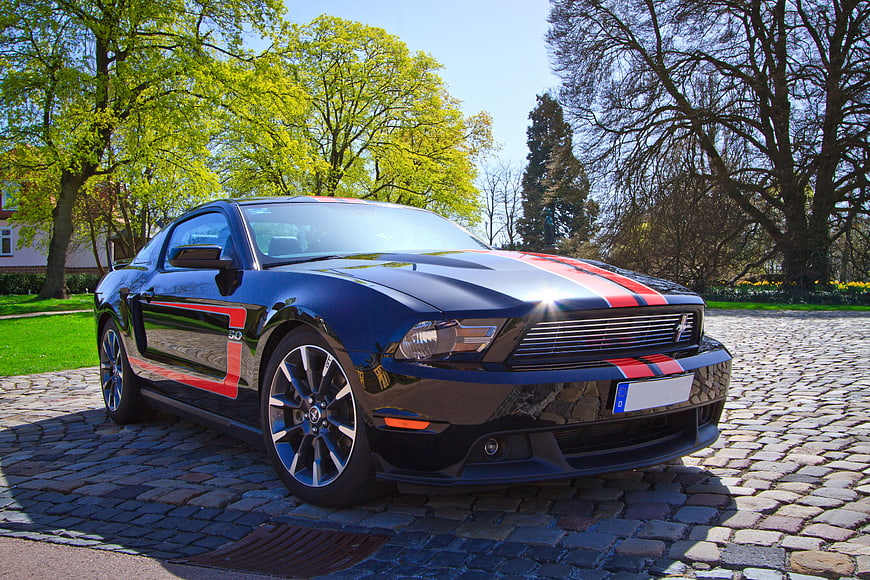 Black Ford Mustang GT with Red Stripes on Cobblestone