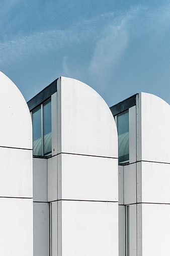 Modern white architectural arches against blue sky