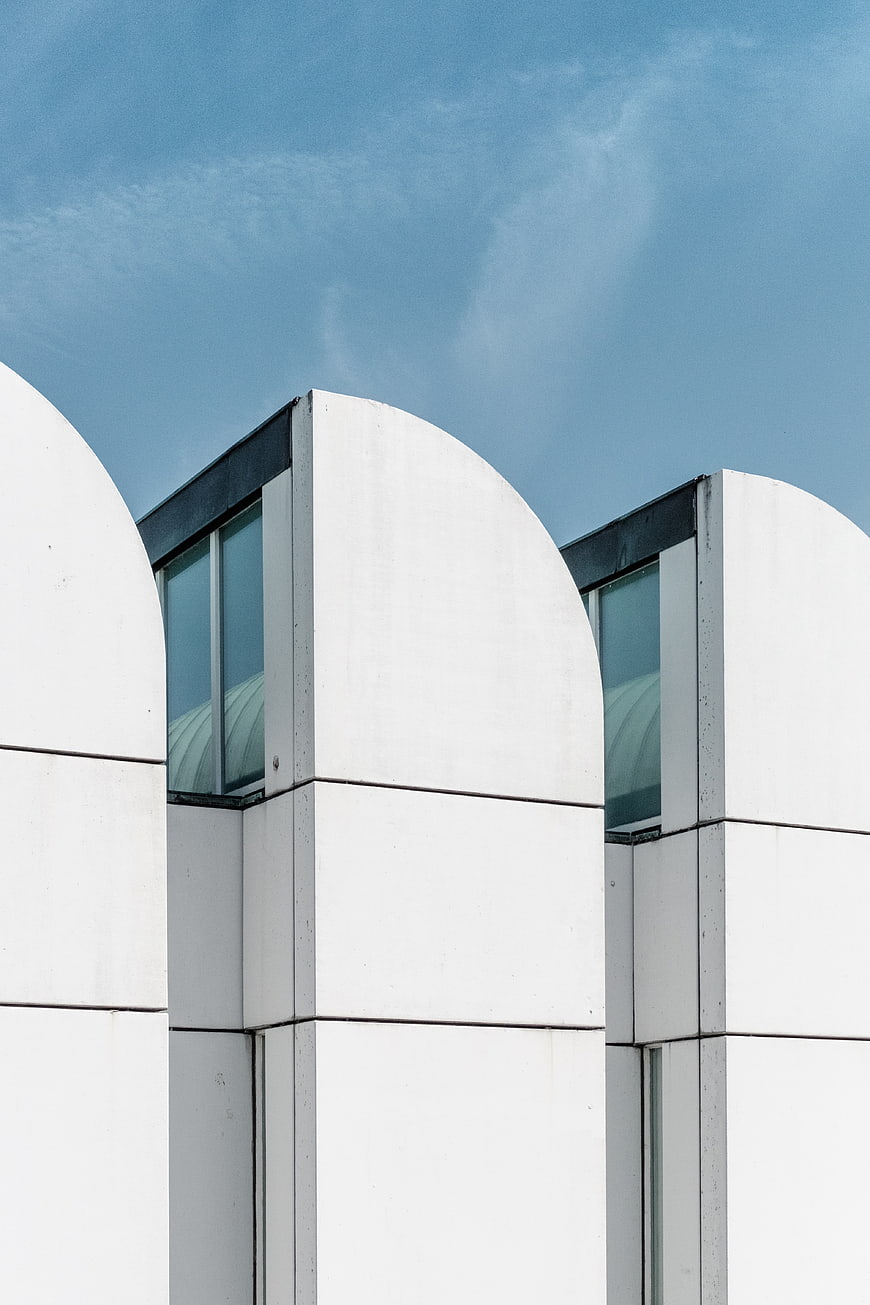 Modern white architectural arches against blue sky
