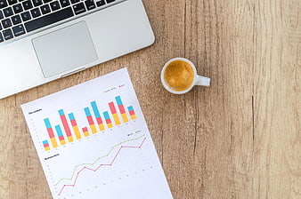Business analytics flat lay with laptop, coffee, and financial charts