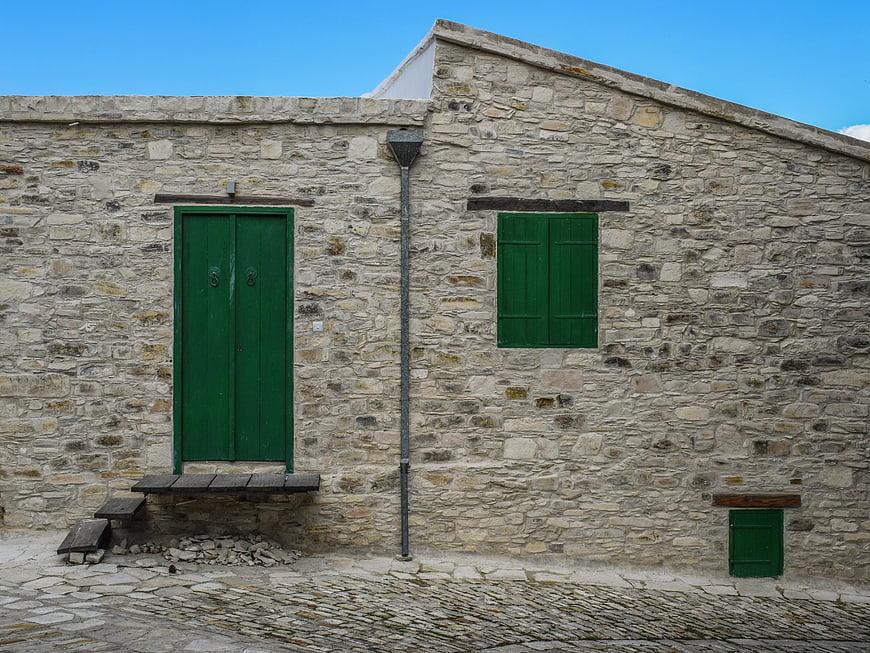 Rustic Stone House with Green Door and Shutters