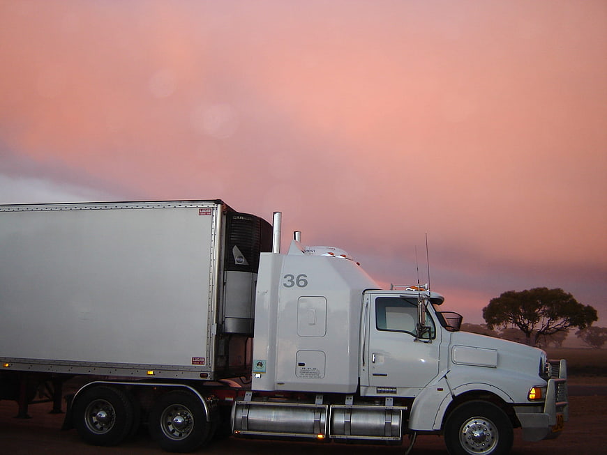 White Semi Truck Parked Against Pink Sunset Sky