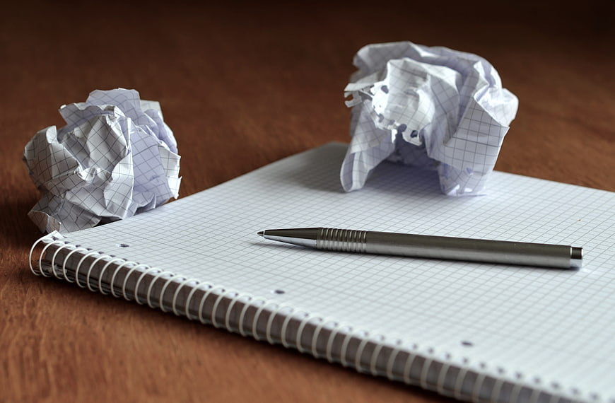 Crumpled paper balls and pen on graph paper notebook