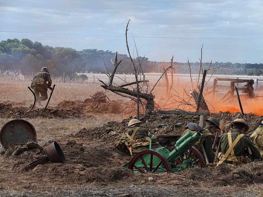 WWI reenactment soldiers firing artillery in trench