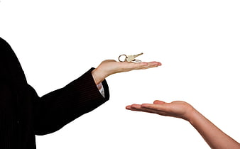 Real estate agent handing keys to buyer on white background