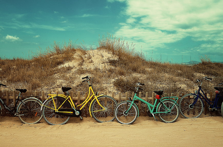 Colorful Bicycles Parked on Sandy Beach Dunes