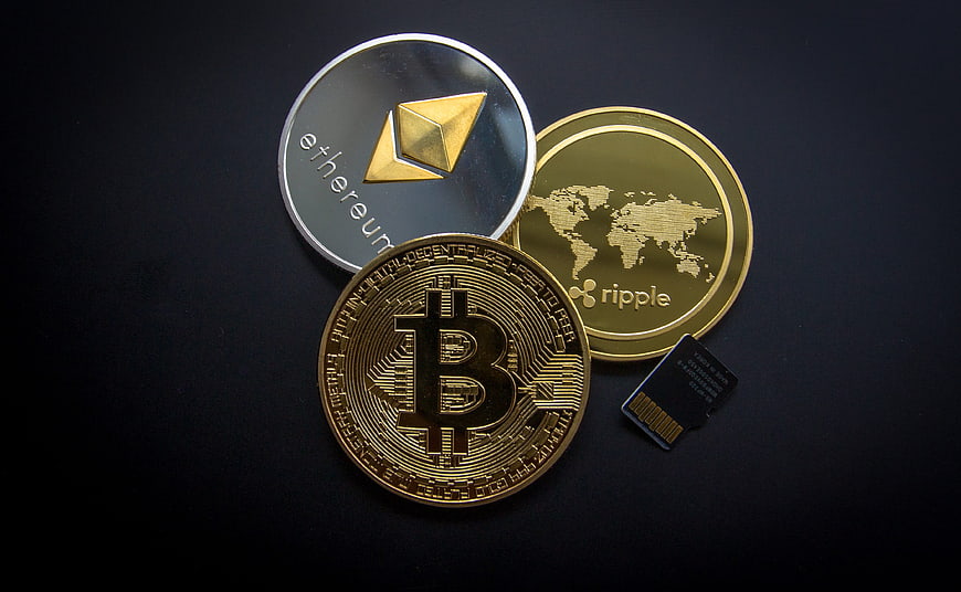Bitcoin, Ethereum, and Ripple Coins with SD Card on Black Background