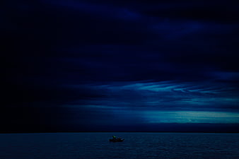 Lone Boat on Dark Ocean Under Stormy Night Sky