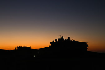 Silhouette of Rooftop with Birds Against Sunset Sky