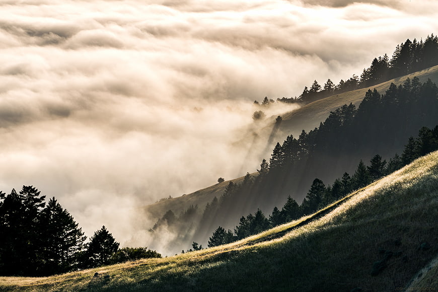 Misty Mountain Landscape with Sunbeams Through Clouds