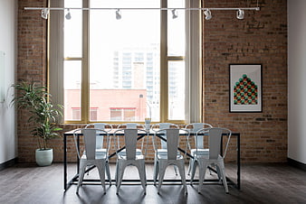 Modern industrial dining room with brick walls and metal chairs