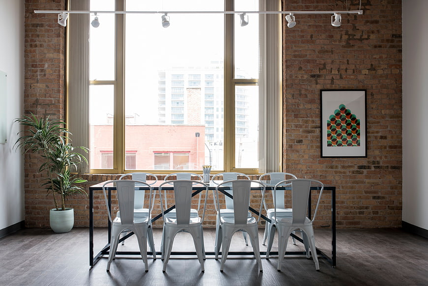Modern industrial dining room with brick walls and metal chairs