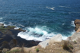 Ocean waves crashing against rocky coastal cliffs