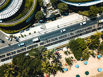 Aerial View of Beach Road with Scooters and Blue Umbrellas