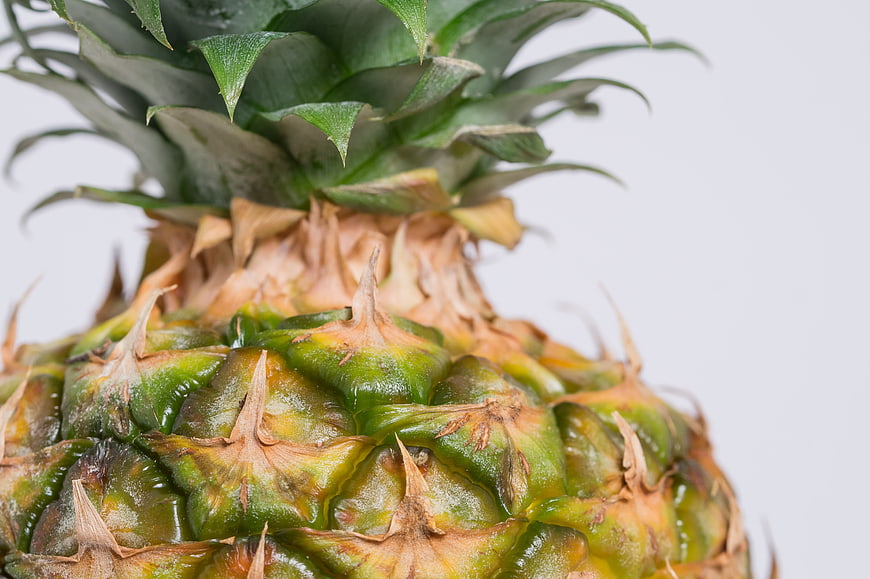 Close-up of fresh green pineapple texture on white background