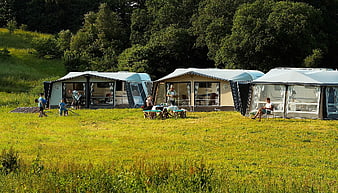 Luxury Glamping Tents In Green Meadow With People Relaxing